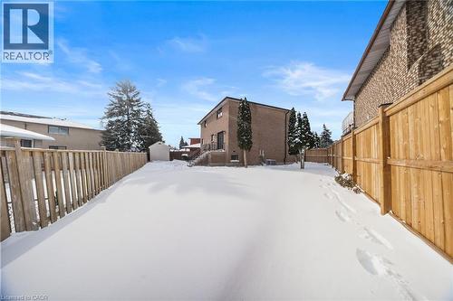 Yard layered in snow with a fenced backyard and an outdoor structure - 16 Bosna Court, Hamilton, ON - Outdoor