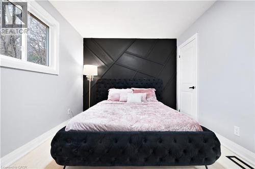 Bedroom with an accent wall, a decorative wall, and light wood-type flooring - 19 Broad Street, Brantford, ON - Indoor Photo Showing Bedroom