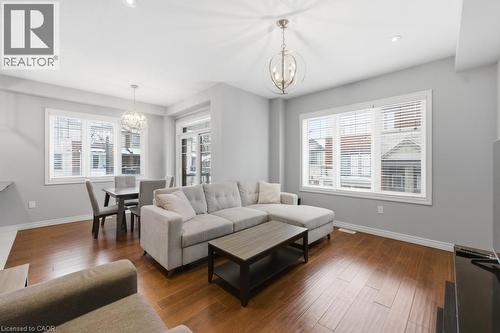 Living area with suspended lighting, wood-type flooring, and healthy amount of natural light - 4 Andruss Lane, Ancaster, ON - Indoor Photo Showing Living Room