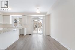 Kitchen with white cabinetry, a healthy amount of sunlight, sink, and light wood-type flooring - 