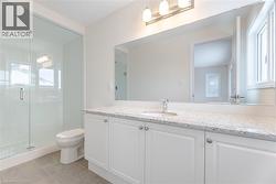 Bathroom with tile patterned flooring, vanity, a shower with door, and toilet - 