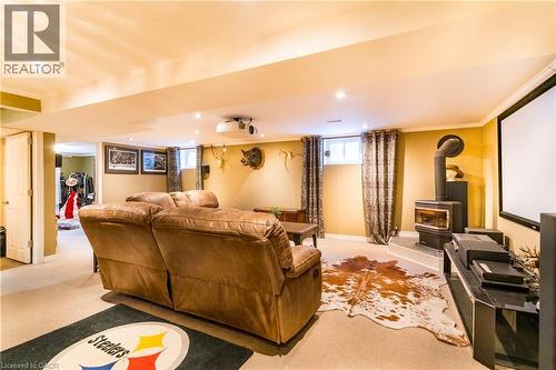 Spacious family room with cozy gas fireplace and 92"" entertainment station - 102 Greeningdon Drive, Hamilton, ON - Indoor With Fireplace