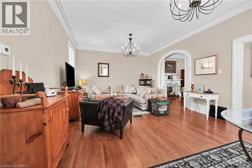 Living room with an inviting chandelier, ornamental molding, and hardwood / wood-style floors - 40 Locke Street S, Hamilton, ON - Indoor