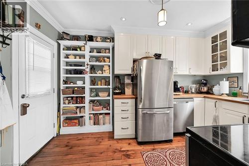 Kitchen with pendant lighting, light hardwood / wood-style floors, white cabinetry, and appliances with stainless steel finishes - 40 Locke Street S, Hamilton, ON - Indoor Photo Showing Kitchen