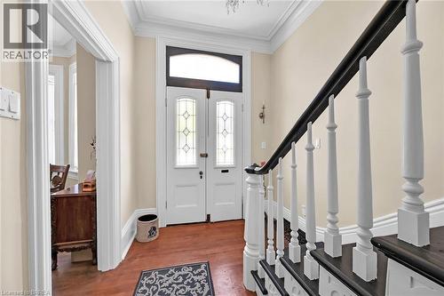 Foyer entrance featuring french doors, dark hardwood / wood-style flooring, crown molding, and a notable chandelier - 40 Locke Street S, Hamilton, ON - Indoor Photo Showing Other Room