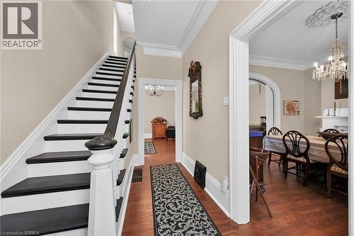 Stairway featuring an inviting chandelier, ornamental molding, and hardwood / wood-style floors - 40 Locke Street S, Hamilton, ON - Indoor Photo Showing Other Room