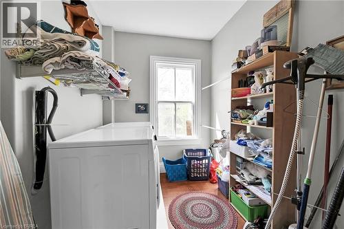 Clothes washing area with hardwood / wood-style flooring and separate washer and dryer - 40 Locke Street S, Hamilton, ON - Indoor Photo Showing Laundry Room