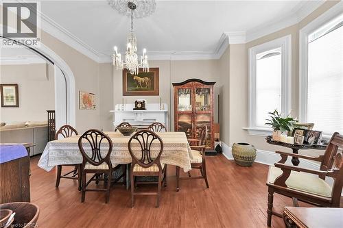 Dining space featuring a notable chandelier, ornamental molding, and hardwood / wood-style flooring - 40 Locke Street S, Hamilton, ON - Indoor Photo Showing Dining Room