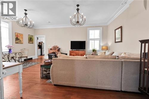 Living room with hardwood / wood-style flooring, ornamental molding, and a notable chandelier - 40 Locke Street S, Hamilton, ON - Indoor Photo Showing Living Room