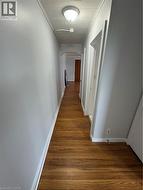 Hall featuring wood finished floors and crown molding - 
