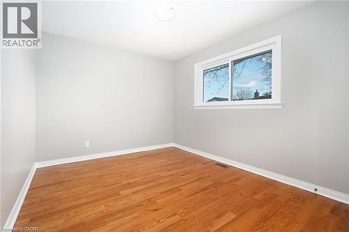 Empty room with wood finished floors and baseboards - 325 East 16Th Street, Hamilton, ON - Indoor Photo Showing Other Room