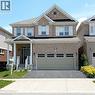 View of front of house featuring a porch, concrete driveway, a garage, and brick siding - 50 Shoreacres Drive, Kitchener, ON  - Outdoor With Facade 