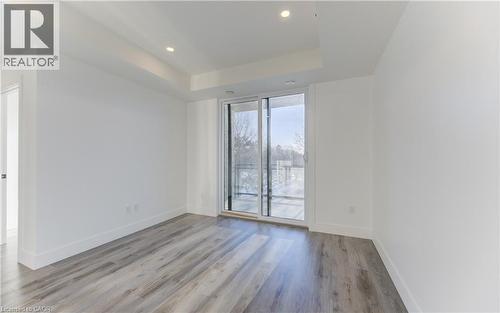 Spare room with light wood-style floors, a raised ceiling, and recessed lighting - 103 Roger Street Unit# 310, Waterloo, ON - Indoor Photo Showing Other Room