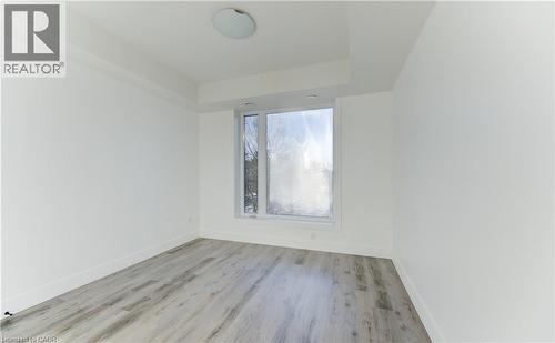 Spare room with light wood-style floors and a raised ceiling - 103 Roger Street Unit# 310, Waterloo, ON - Indoor Photo Showing Other Room