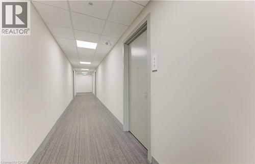 Hallway with a paneled ceiling and light colored carpet - 103 Roger Street Unit# 310, Waterloo, ON - Indoor Photo Showing Other Room