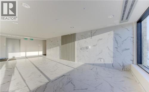Unfurnished room featuring marble tiled flooring, stone wall, and recessed lighting - 103 Roger Street Unit# 310, Waterloo, ON -  Photo Showing Other Room