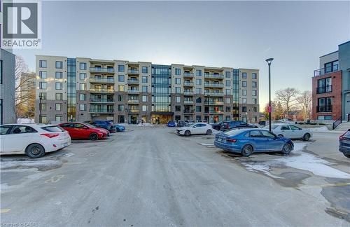 View of uncovered parking lot - 103 Roger Street Unit# 310, Waterloo, ON - Outdoor With Facade