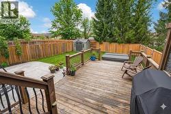 Deck with a storage shed, a fenced backyard, and a grill - 