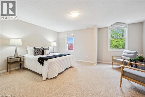 Bedroom featuring light carpet, multiple windows, and a textured ceiling - 66 Rodgers Road Unit# 2, Guelph, ON - Indoor Photo Showing Bedroom