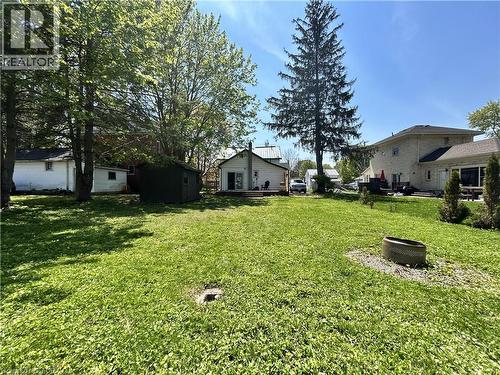 Expansive rear lawn featuring mature trees, a detached shed, and a private deck area - 101 John Street E, Wingham, ON - Outdoor