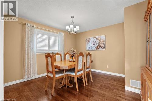 Dining area with dark hardwood flooring, suspended lighting, and a textured ceiling - 42 Archer Way, Hamilton, ON - Indoor Photo Showing Dining Room