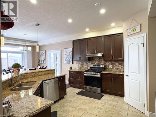 Kitchen featuring sink, hanging light fixtures, dark brown cabinets, stainless steel appliances, and tasteful backsplash - 34 Watervale Drive Unit# Upper, Kitchener, ON - Indoor Photo Showing Kitchen With Double Sink With Upgraded Kitchen