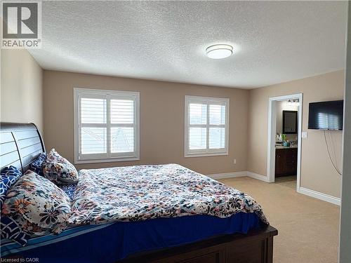 Carpeted bedroom with connected bathroom and a textured ceiling - 34 Watervale Drive Unit# Upper, Kitchener, ON - Indoor Photo Showing Bedroom