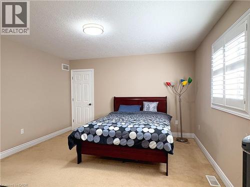 Carpeted bedroom featuring multiple windows and a textured ceiling - 34 Watervale Drive Unit# Upper, Kitchener, ON - Indoor Photo Showing Bedroom