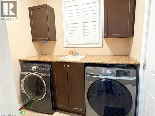 Washroom featuring cabinets, washer / clothes dryer, sink, and light tile patterned floors - 34 Watervale Drive Unit# Upper, Kitchener, ON - Indoor Photo Showing Laundry Room