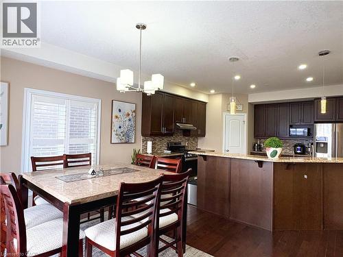Kitchen with tasteful backsplash, hanging light fixtures, dark brown cabinets, and stainless steel appliances - 34 Watervale Drive Unit# Upper, Kitchener, ON - Indoor Photo Showing Dining Room