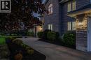 Stone masonry exterior with an arched window, a concrete driveway, established landscaping, and exterior wall sconces - 1 Brown Avenue, Cambridge, ON  - Outdoor 