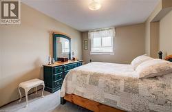 Bedroom featuring light colored carpet and a textured ceiling - 