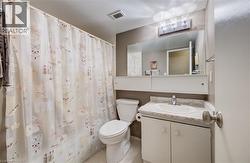 Full bath featuring vanity, a shower with curtain, and light tile patterned floors - 