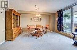 Dining room featuring light carpet, hanging lights, and a textured ceiling - 