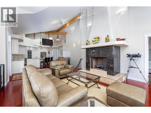 Brazilian cherry hardwood flooring - 375 Trumpeter Court, Kelowna, BC - Indoor Photo Showing Living Room With Fireplace