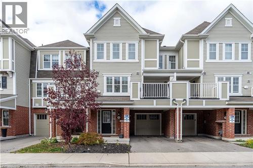 Traditional-style home featuring a balcony, driveway, brick siding, and a garage - 143 Ridge Road Unit# 48, Cambridge, ON - Outdoor With Balcony With Facade