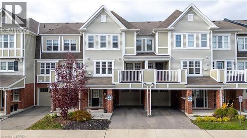 View of front of house featuring driveway, a residential view, a garage, brick siding, and a balcony - 143 Ridge Road Unit# 48, Cambridge, ON - Outdoor With Facade