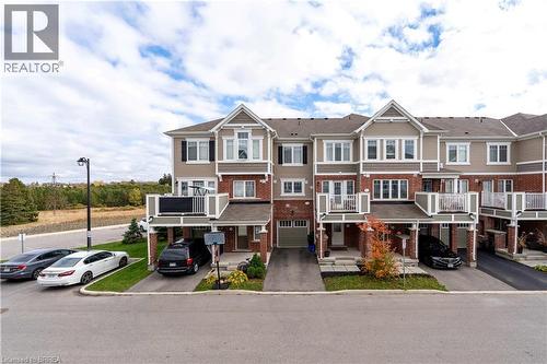 View of front of home with brick siding, driveway, and an attached garage - 143 Ridge Road Unit# 48, Cambridge, ON - Outdoor With Facade