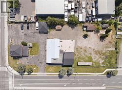 Commercial property featuring multiple structures, paved parking areas, and a substantial undeveloped lot - 