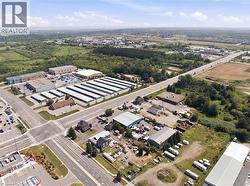 Aerial perspective showcasing a commercial property with multiple buildings and a large paved lot - 