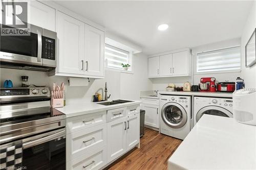 Kitchen-Laundry area with dark wood-type flooring, washer and dryer, and recessed lighting - 90 Toby Crescent Unit# Lower, Hamilton, ON - Indoor Photo Showing Laundry Room