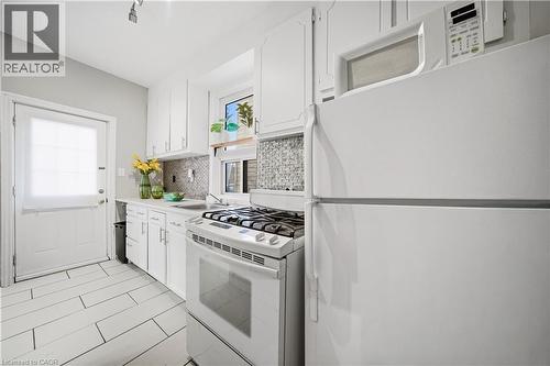 Kitchen (Main Floor). Gas Stove, Ceramic Back-splash and Flooring, Back Door Leads to Yard & Parking - 107 Queen Street S, Hamilton, ON - Indoor Photo Showing Kitchen