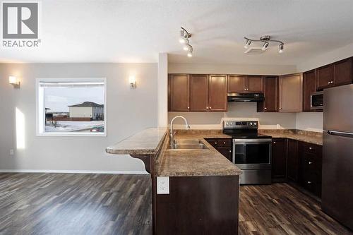 Kitchen w/Breakfast Bar - 322 17 Street E, Brooks, AB - Indoor Photo Showing Kitchen With Double Sink
