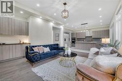 Living area with light wood-type flooring, recessed lighting, and a chandelier - 