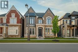 View of front of home featuring stone siding, a front yard, and brick siding - 