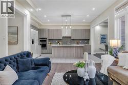 Living area with light wood-style flooring and recessed lighting - 