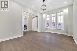 Empty room featuring a chandelier, dark wood-type flooring, and recessed lighting - 