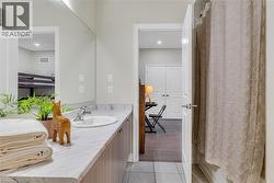 Full bathroom with vanity and light tile patterned floors - 