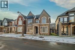 View of front facade with a residential view, brick siding, a standing seam roof, and stone siding - 