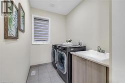 Washroom with light tile patterned floors and washing machine and clothes dryer - 